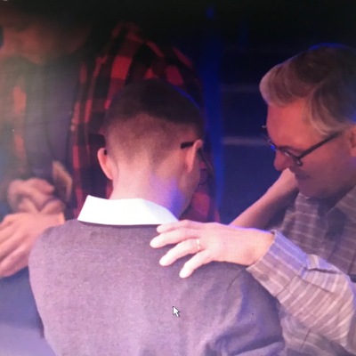 Men praying for each other at First Revival