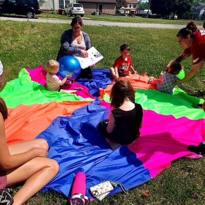 Taking advantage of the nice weather and doing Storyhour outside on the parachute.