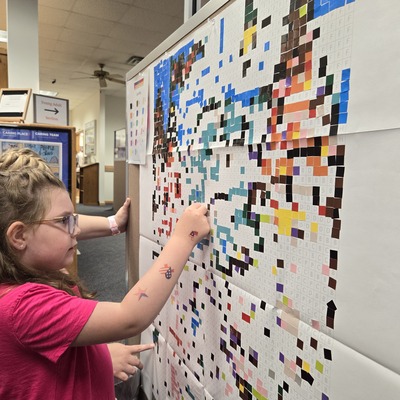 Adding stickers to our StickTogether poster during Summer Reading!