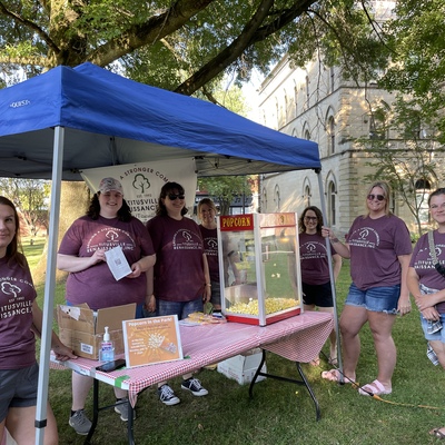 TRI Board of Directors serving free popcorn at TCA's Concert in the Park