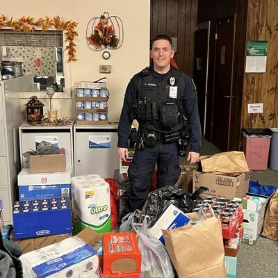 Officer Nick Mogul delivering donations from the "Stuff the Cruiser" yearly event